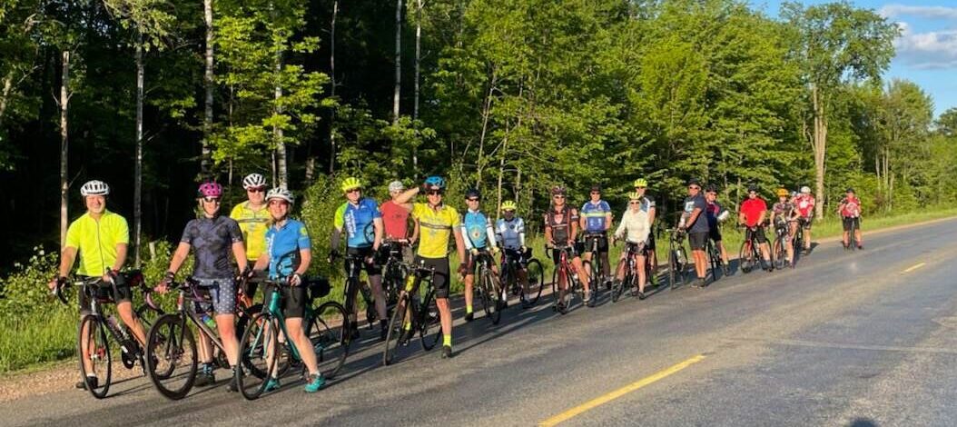 group of road cyclists paused at an intersection