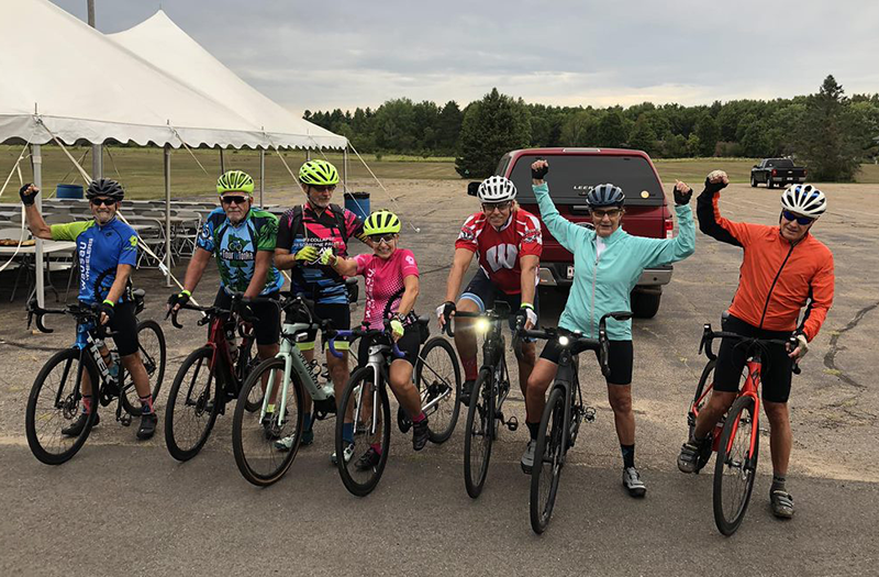 group of road cyclists in parking lot of event, getting ready to ride