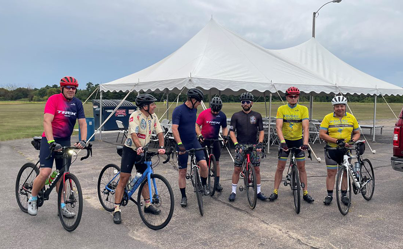 group of road cyclists in parking lot of event, getting ready to ride